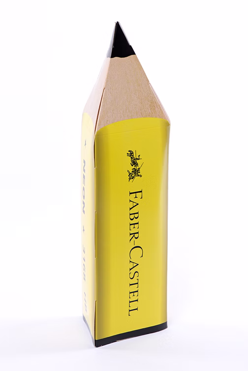 Large yellow Faber-Castell pencil box shaped like a giant pencil with a real pencil lying next to it.